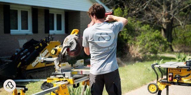 Greater Lansing deck builder sawing composite decking at Custom Built Design and Remodeling project