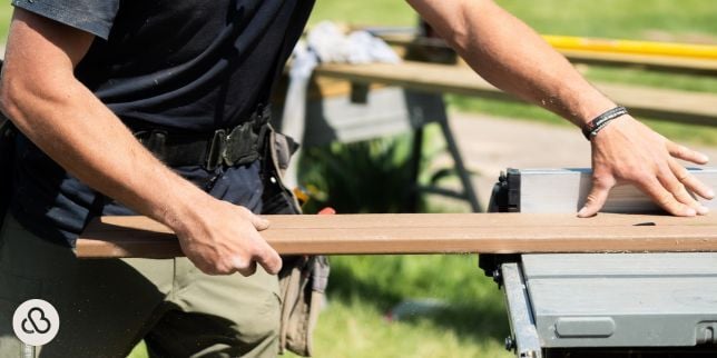Greater Lansing composite deck builder sawing decking board for Custom Built Design and Remodeling