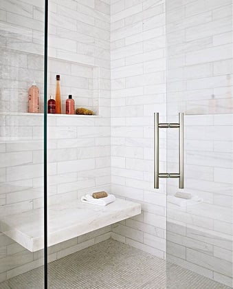 White-tiled, glass shower bathroom with floating bench