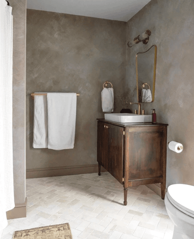 Bathroom with brown limewash paint and antique vanity