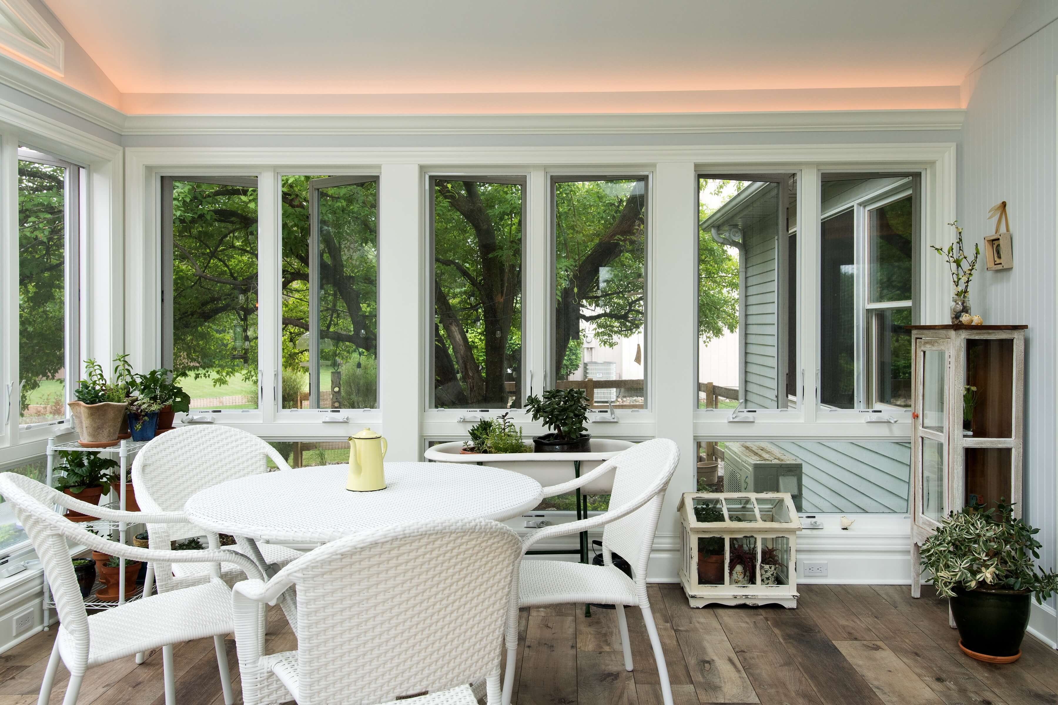 Interior view of home addition with wooden floor, led lights, and patio table
