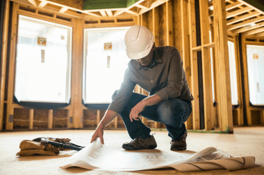 michigan contractor reviewing building permit while inspecting remodeling project custom built