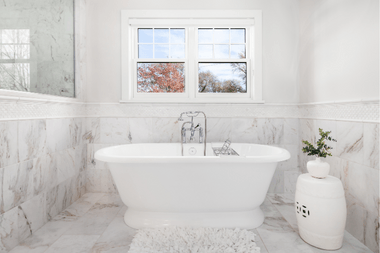 standalone bathtub in bathroom remodel with plant and marble custom built michigan