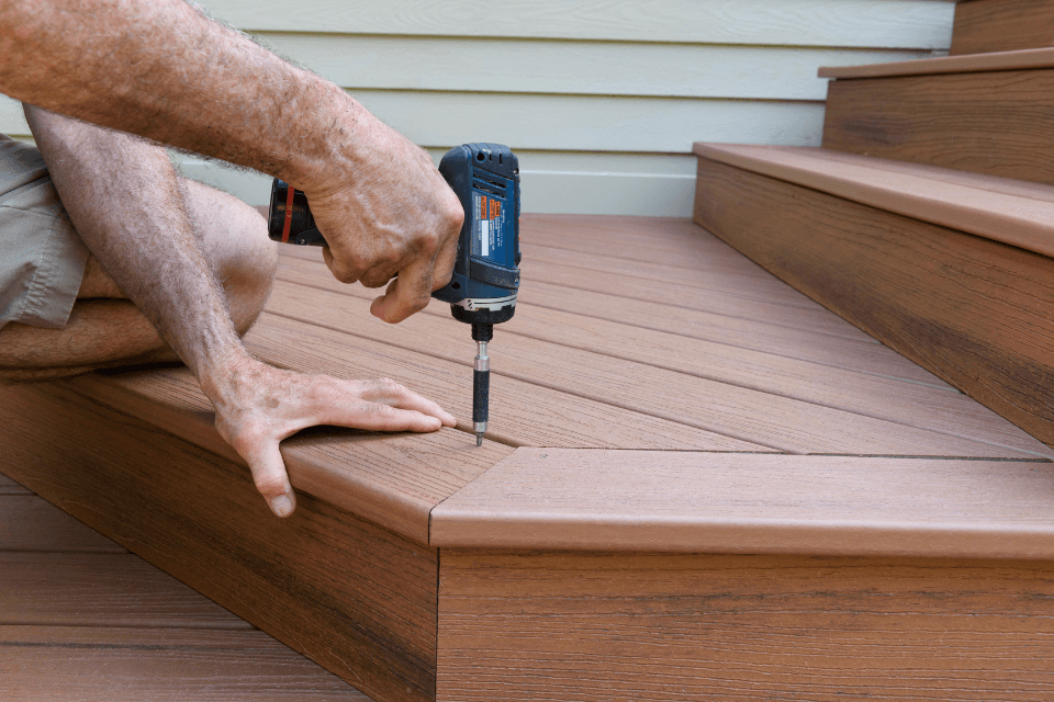 red flags composite deck contractor installing boards with a drill custom built michigan