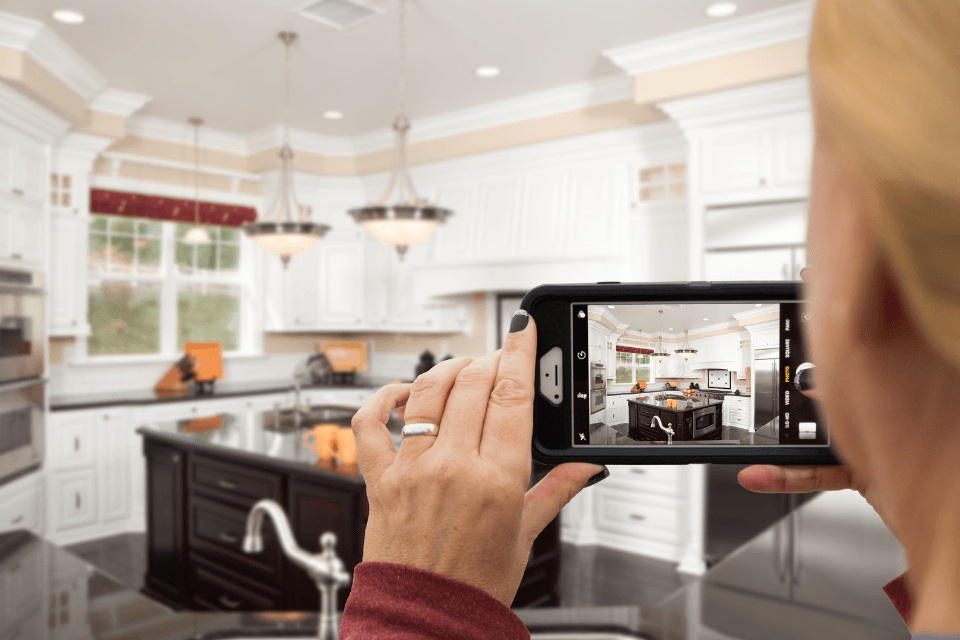 Woman taking a picture of a kitchen