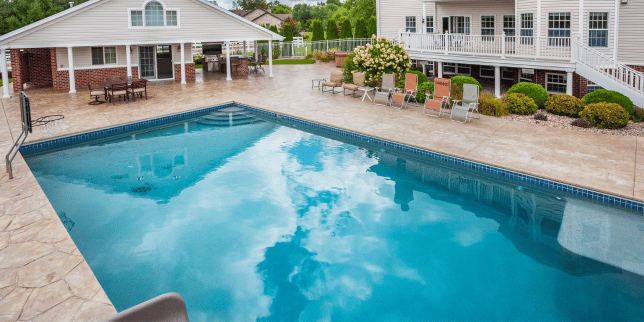concrete pool decks an honest review outdoor living space with lounge chairs and pavilion custom built michigan
