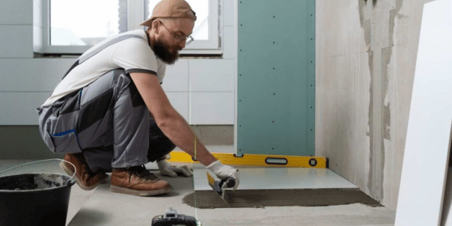 Greater Lansing home remodeling contractor spreading caulk in bathroom remodel