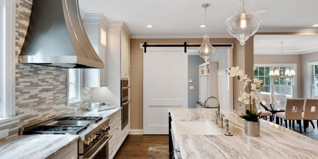 Greater Lansing kitchen remodeling project with large quartz countertops and decorative hood
