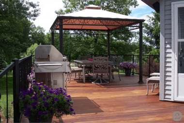 metal pergola with covered dining area on composite decking and glass railings custom built michigan
