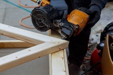 Greater Lansing deck builder sawing wood decking frame