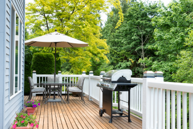 Lansing composite deck with white railings and bbq grill