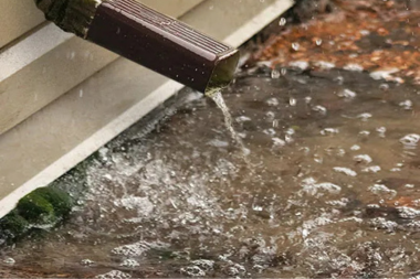 Lansing home downspout with pooling around foundation