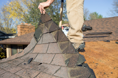 licensed Lansing roofing contractor removing damaged shingles