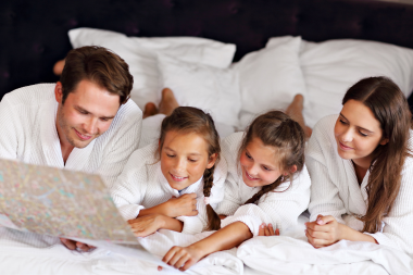 Lansing Michigan family reviewing restaurant menu in hotel bed