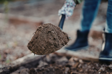 Lansing Michigan deck builder holding shovel of soil
