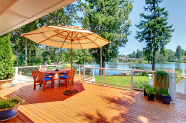 lakefront composite deck with large umbrella and dining table set