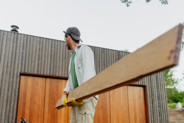 Greater Lansing home remodeler carrying large wood decking boards