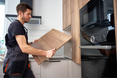 licensed kitchen remodeler in Greater Lansing installing cabinets