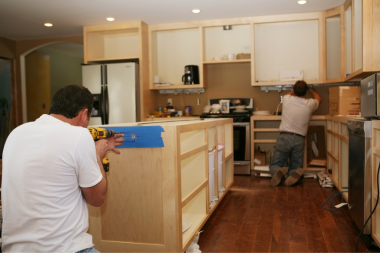 kitchen remodelers in Greater Lansing installing island and cabinets