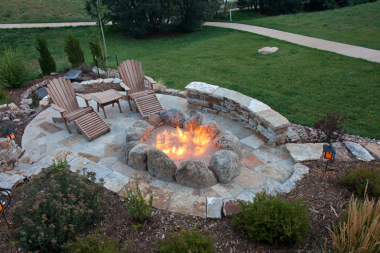 Greater Lansing outdoor living space with stone fire pit and adirondack chairs