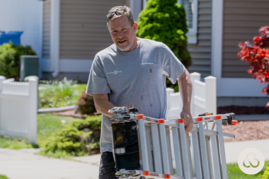 Greater Lansing design build home remodeler carrying ladder