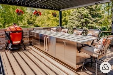 outdoor kitchen on composite deck build in Greater Lansing built by Custom Built Design and Remodeling with black pergola and outdoor seating