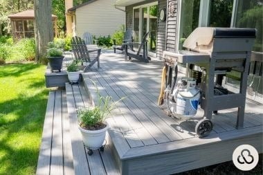 Trex composite deck living space built by Custom Built Design and Remodeling in Greater Lansing with adirondack chairs and bbq grill