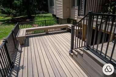 Trex composite deck build in Greater Lansing built by Custom Built Design and Remodeling with built in seating and black railings