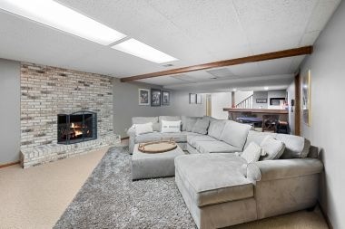 finished basement project in Greater Lansing with sectional couch and brick fireplace