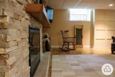 finished basement project in Greater Lansing built by Custom Built Design and Remodeling with brick fireplace and new flooring