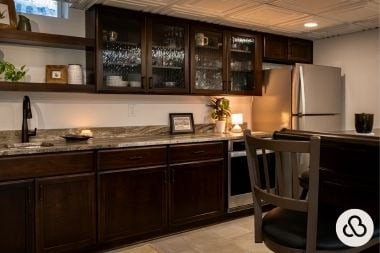 finished basement project in Greater Lansing built by Custom Built Design and Remodeling with wet bar and glass front cabinets