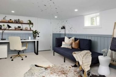home office in basement space with task lighting and sofa