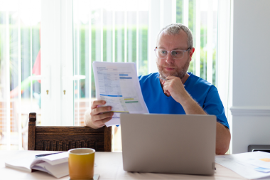 signs you may need a roof replacement in michigan homeowner reviewing home energy bills custom built okemos