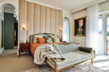 how to design a primary suite addition that feels like a retreat main bedroom with large bed and vaulted ceilings custom built michigan