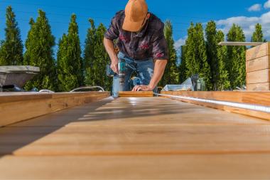 reasons to plan your spring deck build this winter decking contractor installing boards custom built michigan
