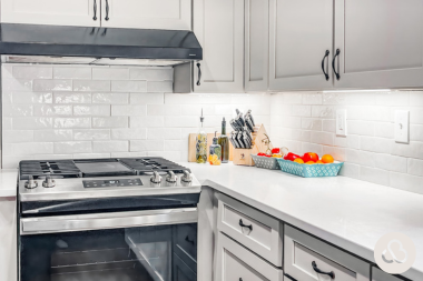 how to plan your kitchen renovation costs around your long term home goals culinary space with white cabinets and tile backsplash custom built michigan