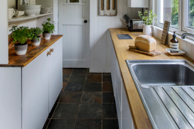 common kitchen layout mistakes homeowners regret later stone tile walkway with wood countertop and large cabinetry custom built michigan