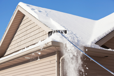 questions to ask your michigan roofing contractor before hiring them remodeler clearing snow off rooftop custom built mi