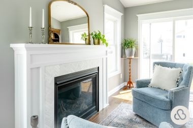 home addition project in Holt Michigan built by Custom Built Design and Remodeling with white fireplace and armchairs