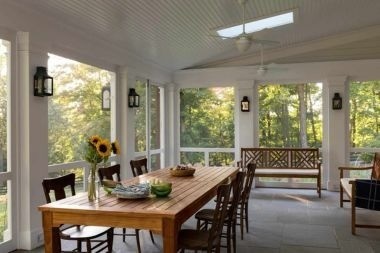 open air screened in porch in Greater Lansing with dining table and lantern lights