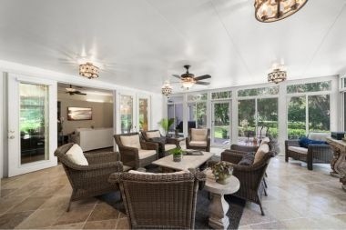 patio enclosure with luxury light fixtures and wicker dining table set