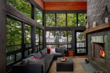 patio enclosure with natural stone fireplace and wood flooring in Greater Lansing