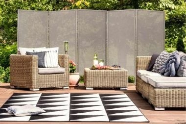 composite deck with temporary privacy screen and wicker outdoor furniture