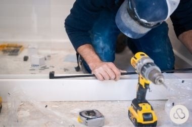 Custom Built Design and Remodeling remodeler installing glass shower door for bathroom remodel in Greater Lansing Michigan