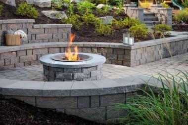 concrete paver patio with fire pit and circular bench in Greater Lansing