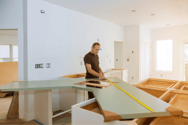luxury kitchen remodeler measuring new island countertop in Greater Lansing