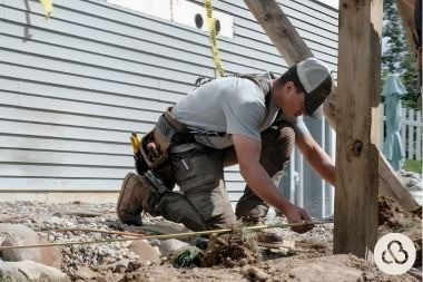 composite deck builder measuring wood posts in Greater Lansing for Custom Built Design and Remodeling