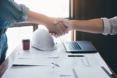 Greater Lansing home addition contractor and homeowner shaking hands