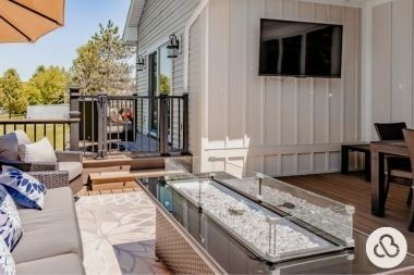 composite deck project in DeWitt Michigan built by Custom Built Design and Remodeling with fire pit table and tv area