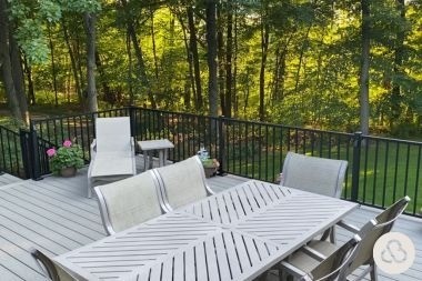 composite deck project in Okemos Michigan built by Custom Built Design and Remodeling with dining table and black aluminum railings